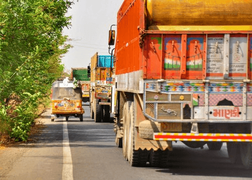 Rickshaw driving by lorries