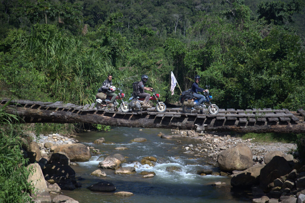 Monkey Run riders on a wooden bridge in the Peruvian Andes