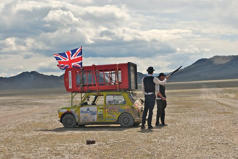Mini on Mongol Rally with red phone box tide to the roof