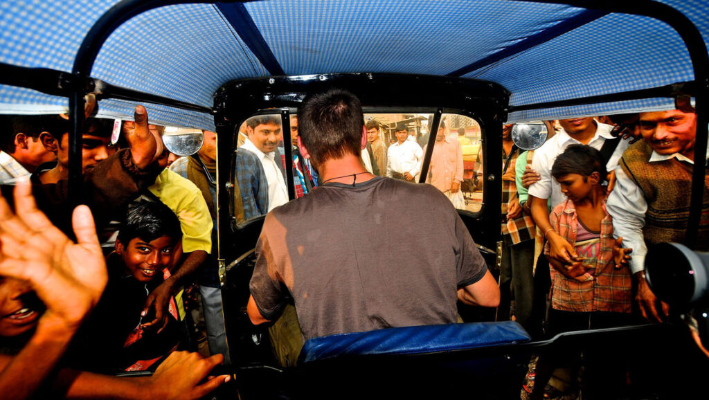 Crowd looking through windscreen of rickshaw on the Rickshaw Run